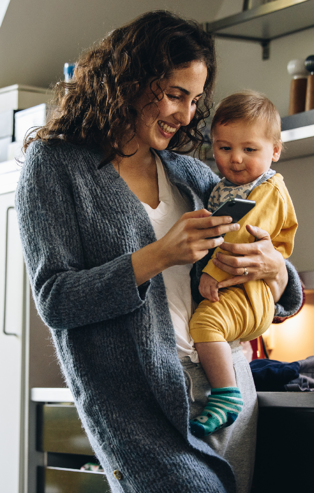 Woman Holding Baby and Phone